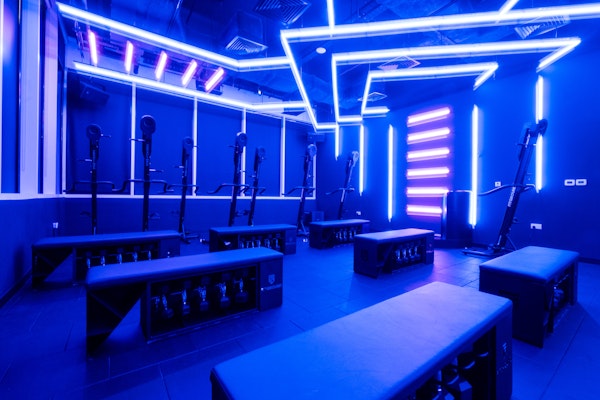 Modern fitness studio with neon lighting and exercise equipment
