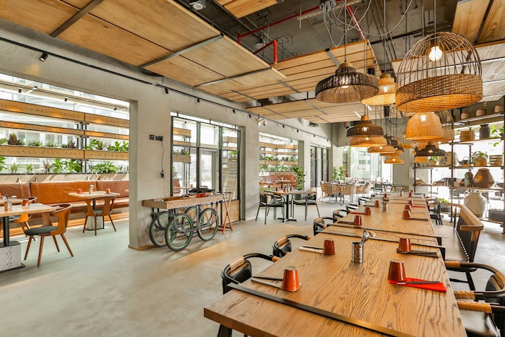 A cozy restaurant interior with wooden tables, industrial-style lighting.