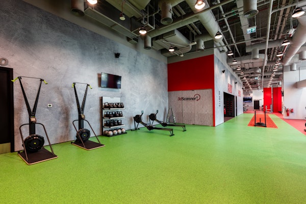 Functional training zone featuring fitness equipment against a vibrant green and red floor
