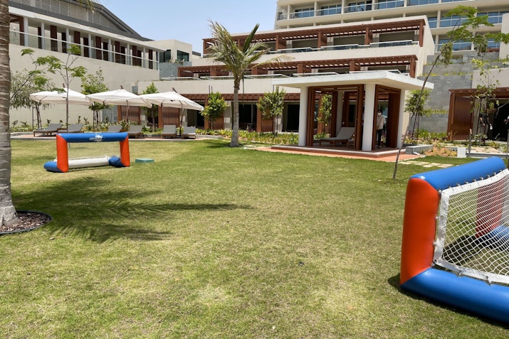 Outdoor space featuring inflatable soccer goals and well-maintained grass near a building