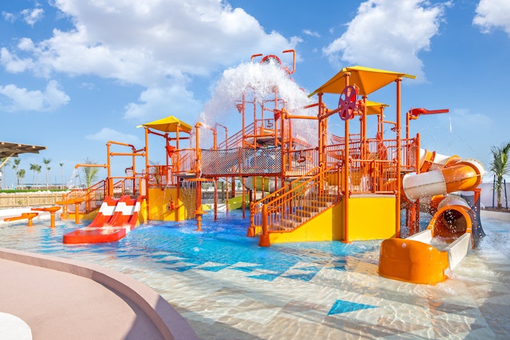 Colorful water park with slides, water features, and a splash zone.