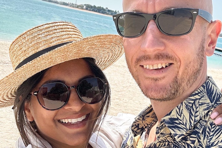 A couple posing for a selfie at the beach.