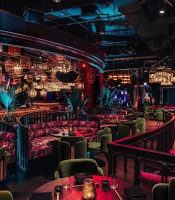 A vibrant and exotic dining experience in Dubai. Colorful and luxurious interior with dim lighting and eclectic decor.