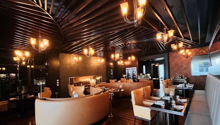 Marco Pierre White Steakhouse & Grill at Fairmont Bab Al Bahr: a refined dining experience. Elegant interior with cozy booths and warm lighting.