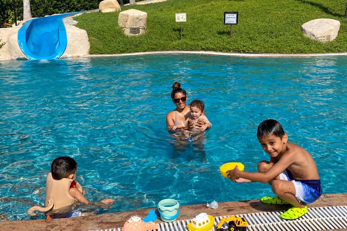 Family enjoying playtime in a swimming pool.