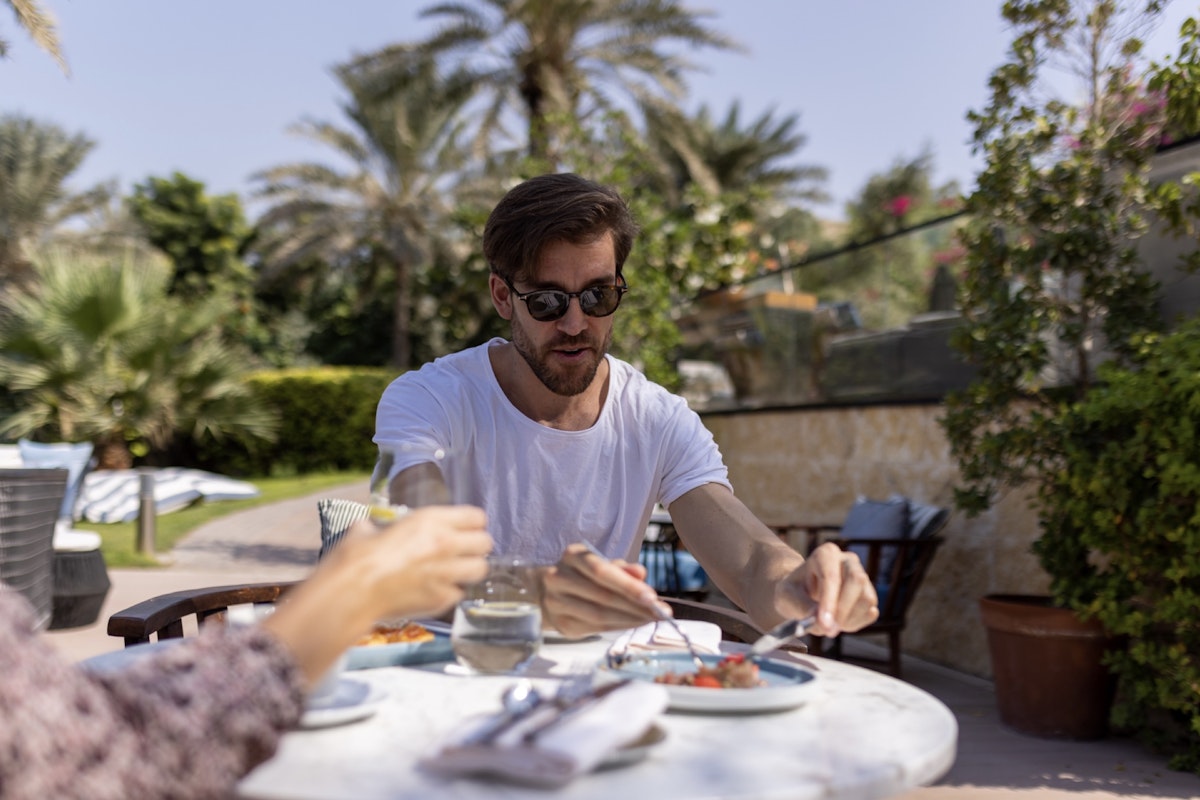 Best poolside meal choices from a health coach! Man having a meal outdoors.