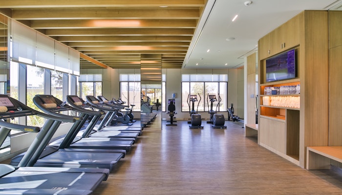 Bodylines Fitness Bright and modern gym interior featuring treadmills and exercise machines with large windows and wooden beams