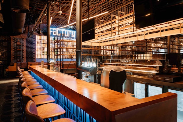 Modern bar setup with stylish seating and industrial decor at The Factory.
