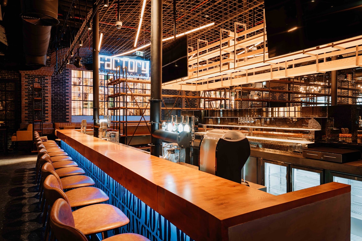 Modern bar setup with stylish seating and industrial decor at The Factory.