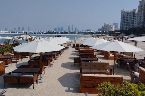 Dine at an American Smokehouse on Palm Jumeirah, Logs & Embers: outdoor seating area with ocean views and cozy lounge seating.