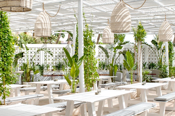 Coastal dining venue featuring fresh seafood and a relaxed atmosphere, overlooking the beach with a chic, nautical design