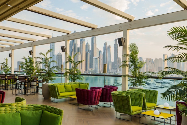 Trendy lounge featuring a stylish ambiance, colourful seating with skyline and ocean views