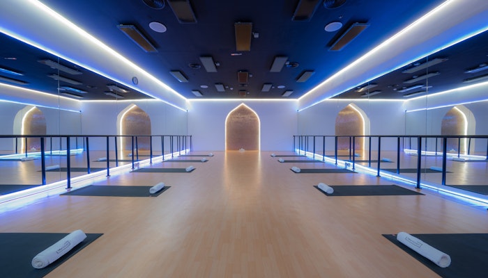 TruFusion Dubai Yoga Studio Modern yoga studio with soft lighting, wooden flooring, yoga mats, and mirrored walls.