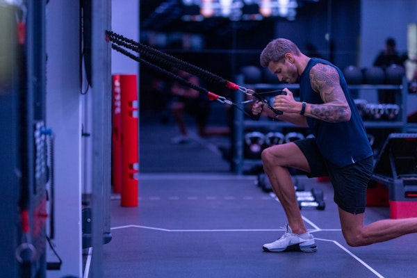 A person performing a workout using resistance bands at a gym.