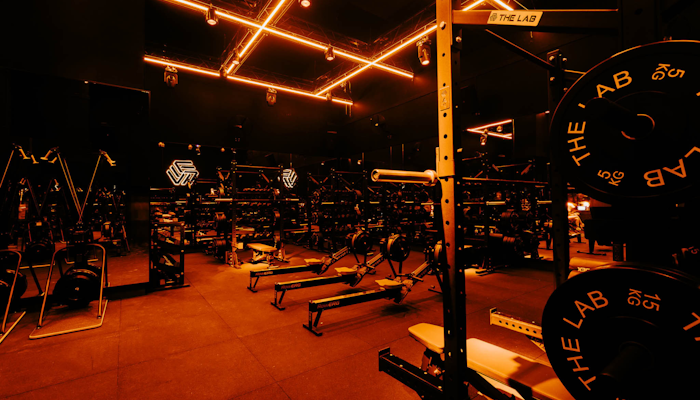 The LAB Studios Dark fitness studio equipped with squat racks, resitance machines, and free weights