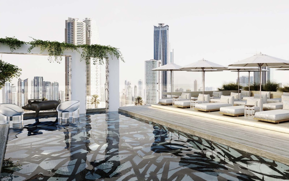Rooftop lounge with a reflective pool, white seating, and parasols.