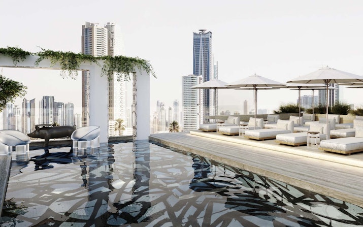 Rooftop lounge with a reflective pool, white seating, and parasols.