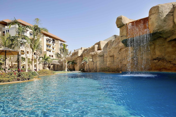 Pool with a waterfall and rocky landscape.