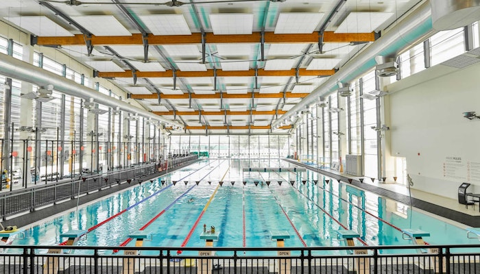 FitRepublik An indoor swimming pool with multiple lanes, large windows, and high ceilings.