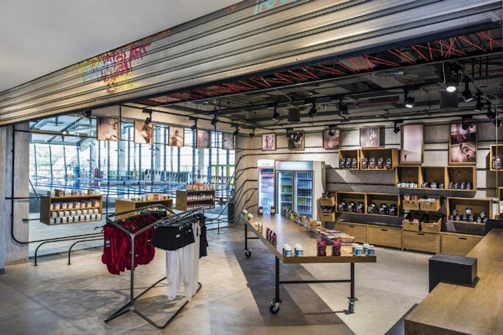An interior view of a modern retail store featuring clothing racks and shelves with various products on display.
