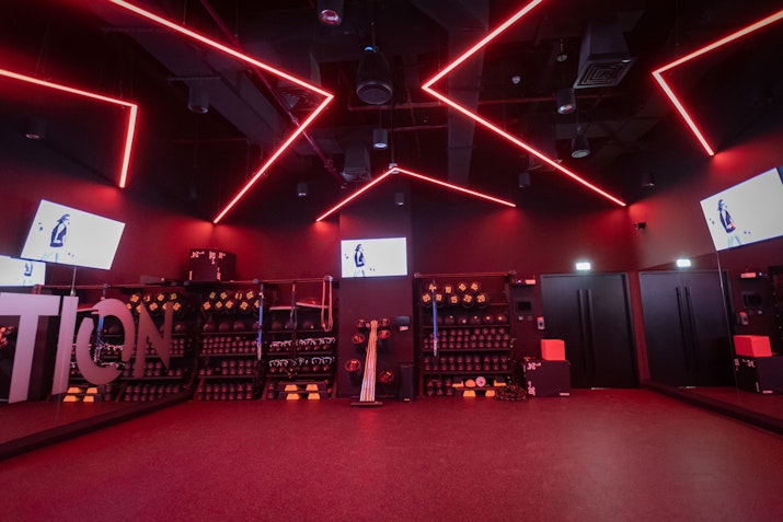 Red fitness studio at FIRE Fit, featuring windows and free weights with dynamic lighting