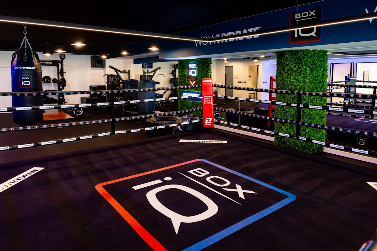 Professional boxing ring with branded flooring and surrounding training equipment.