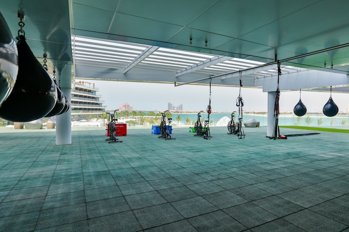 Outdoor gym area with punching bags and exercise equipment overlooking the ocean