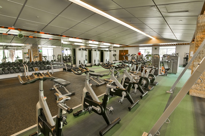 Well-equipped gym with various cardio machines and workout equipment.
