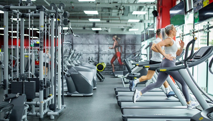 Snap Fitness View of a gym featuring treadmills and strength training equipment, with two people running on treadmills