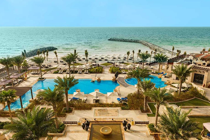Aerial view of a resort pool area overlooking the beach and ocean.