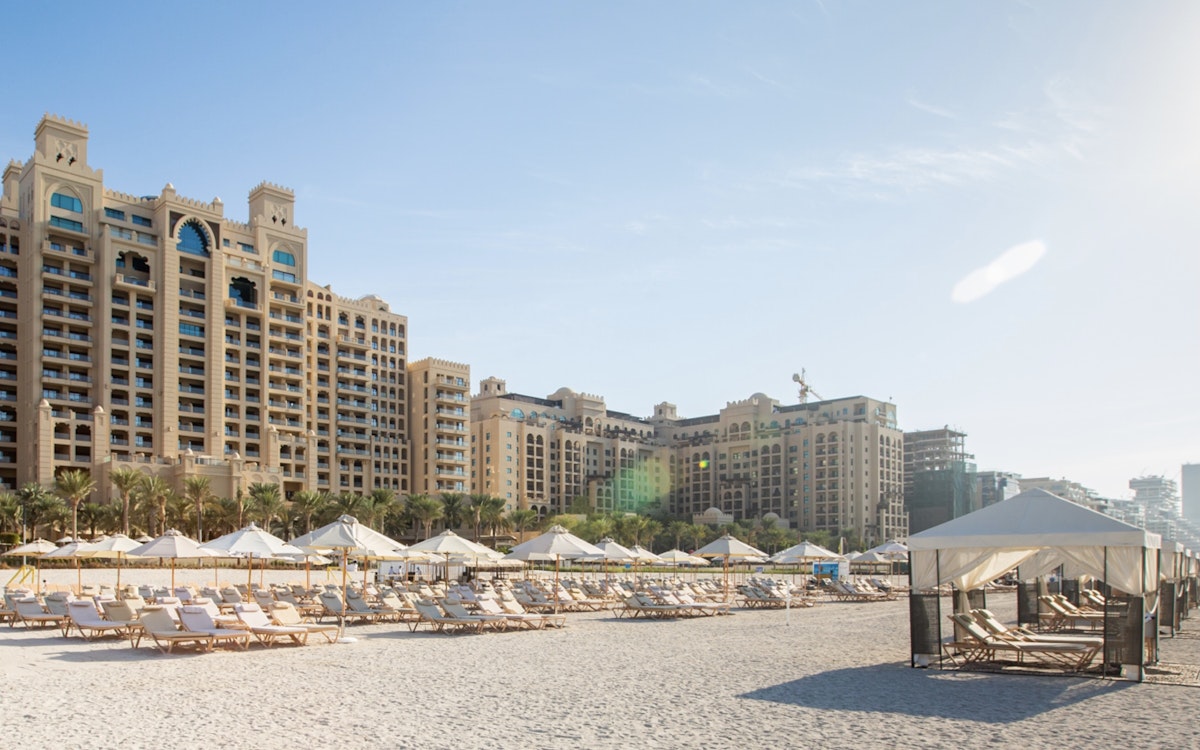 Resort buildings with beach loungers and cabanas on the sand