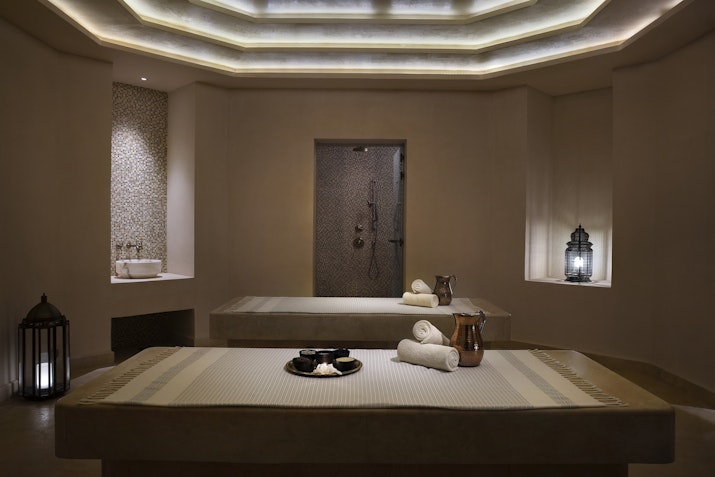 A serene spa room with massage tables, ambient lighting, and decorative lanterns.