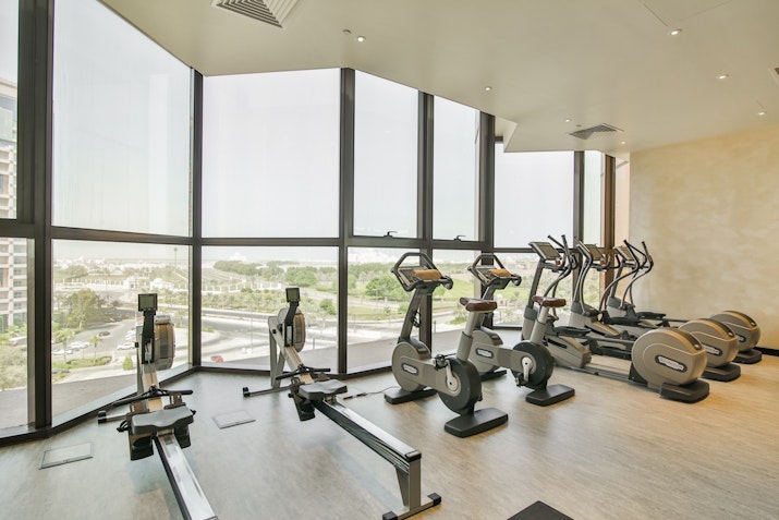 Ayana Fitness at Bab Al Qasr Well-equipped gym with cardio machines and a view of the outside landscape.