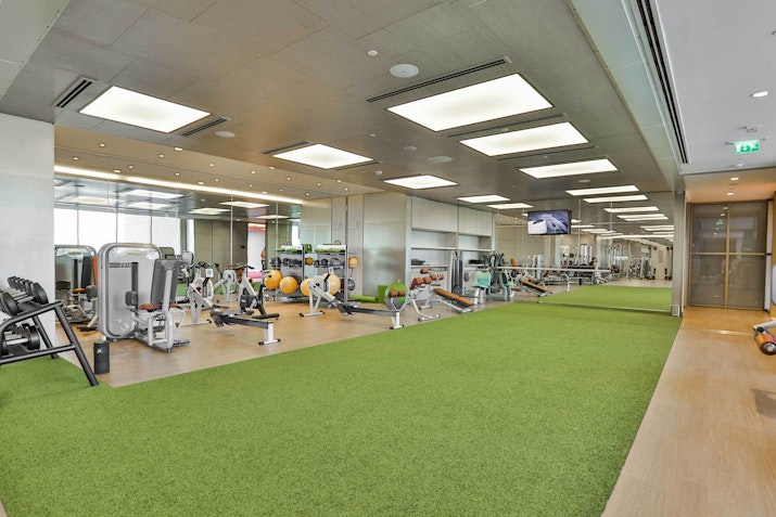 Hyatt Regency Dubai Creek Heights Modern gym with exercise equipment and green turf for workout