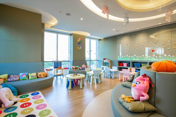 Bright and colorful children's playroom with soft seating and toys.