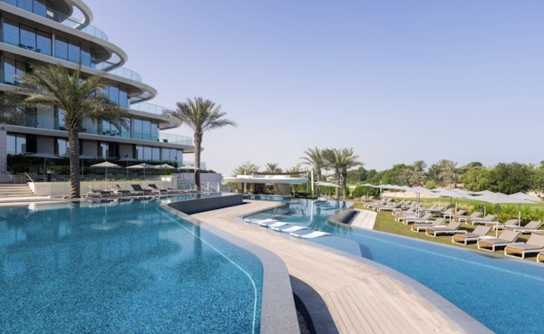 Infinity pool with lounge chairs and modern architecture