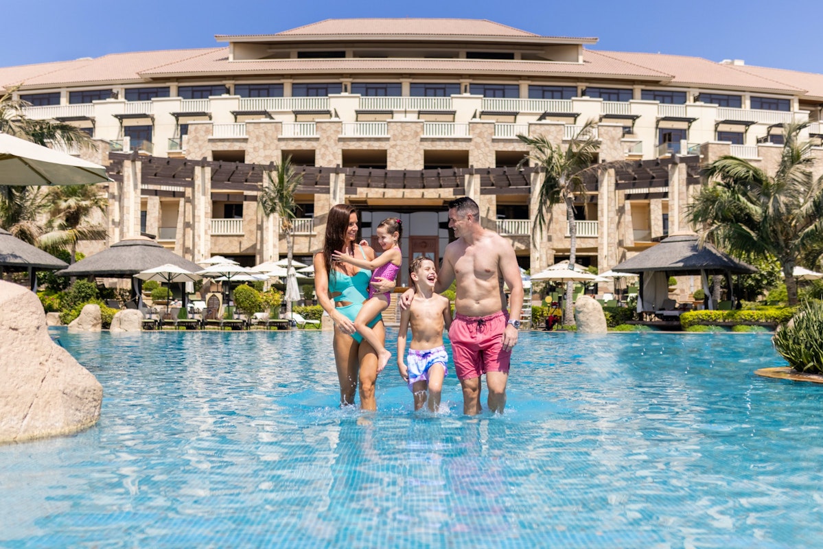 Family walking together in a resort pool.