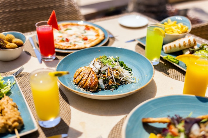 Assorted dishes and colorful drinks on an outdoor dining table