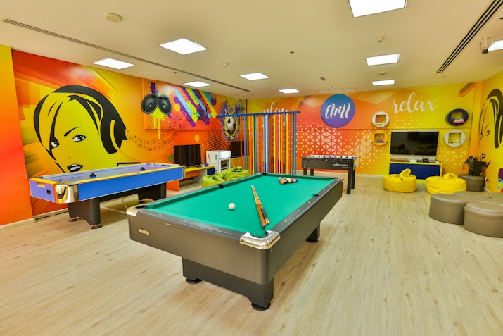 Recreational room with a pool table, ping pong table, and vibrant wall art.