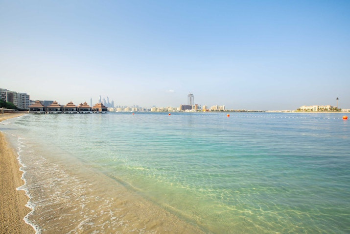 Calm beach with crystal-clear waters and distant skyline