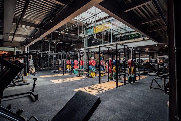 The best gyms and fitness studios in Al Quoz Interior of a gym with workout equipment, weightlifting bars, and colorful weights.