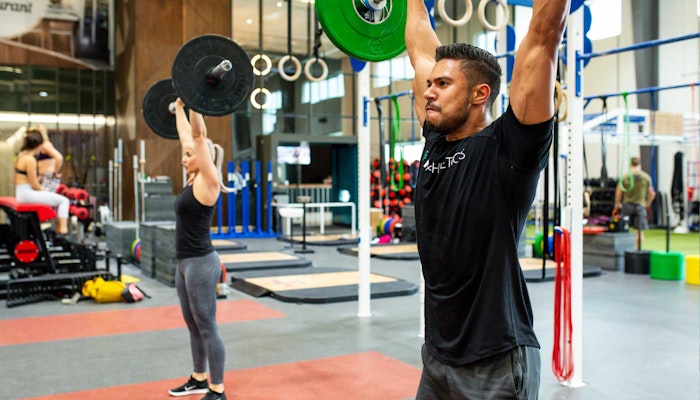 Fly High Fitness CrossFit area equipped with weightlifting bars, kettlebells, and workout rigs for high-intensity training.