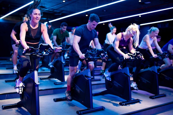Group of people in an intense indoor cycling class
