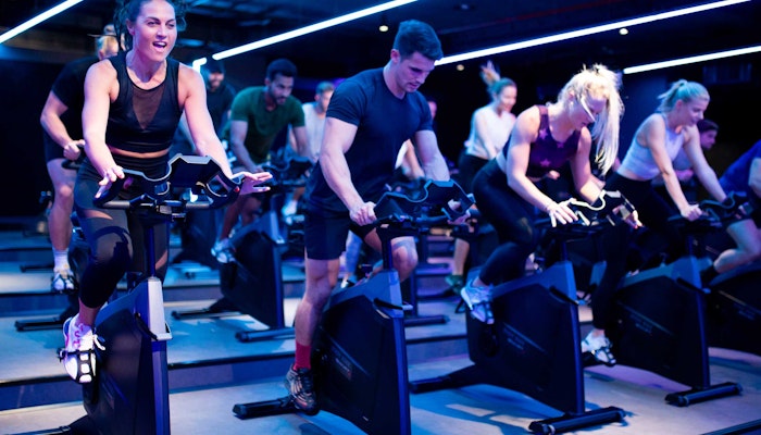 StudioRepublik Group of people in an intense indoor cycling class