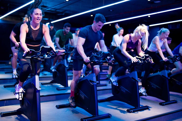Group of people in an intense indoor cycling class