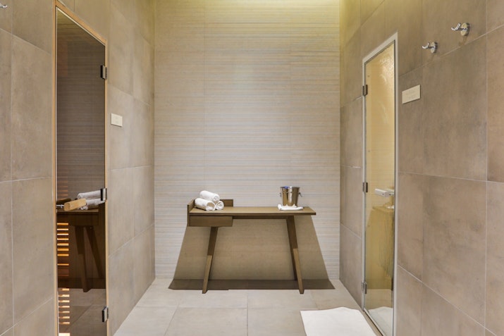 Relax and Rejuvenate Luxury spa room with a wooden table, towels, and separate shower areas.