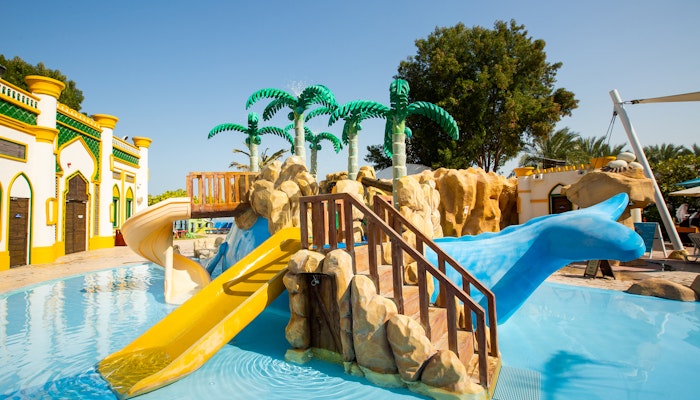 Jumeirah Zabeel Saray Children's pool area with slides and decorative palm trees