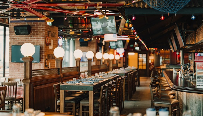 CLAW BBQ The Palm at Hilton Dubai Palm Jumeirah Rustic restaurant interior with globe lights and wooden decor.