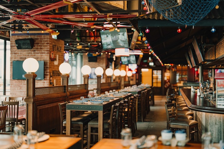 Rustic restaurant interior with globe lights and wooden decor.