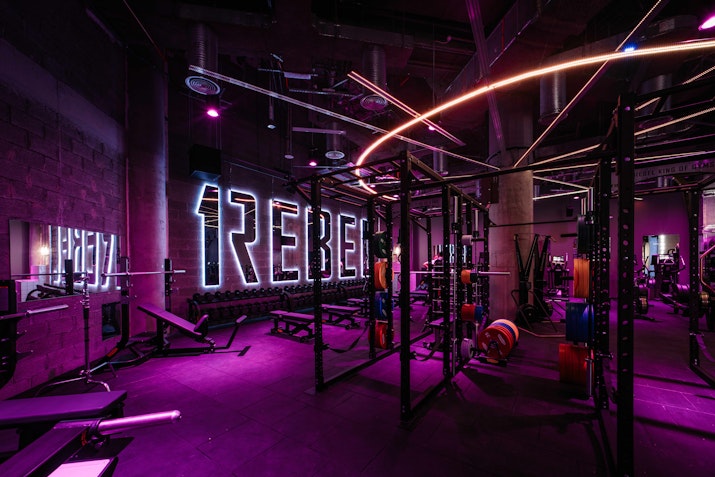 Cutting-edge studio with immersive lighting and advanced fitness equipment, designed for high-intensity workouts.